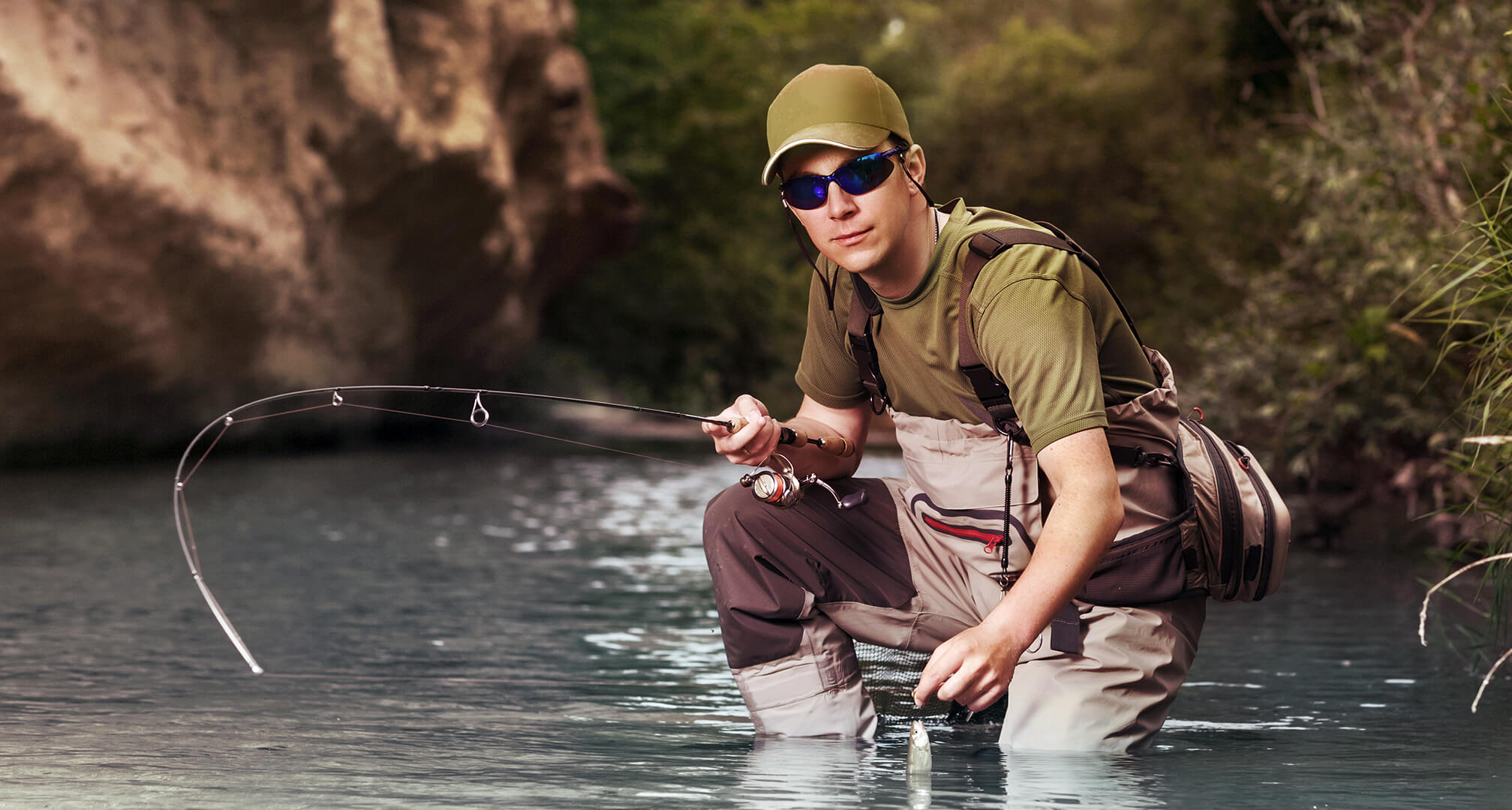 ψαράς σκύβει στο νερό ενώ φοράει γυαλιά ηλίου