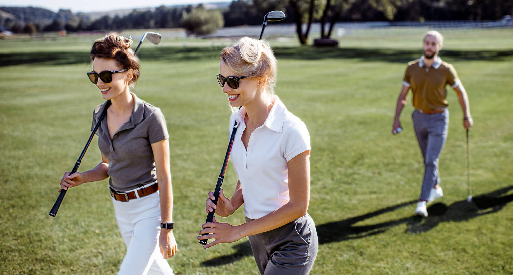 δύο άτομα παίζουν γκολφ φορώντας γυαλιά ηλίου